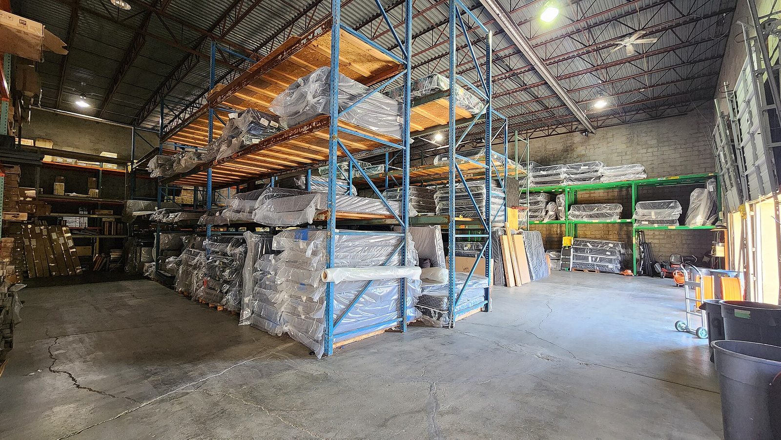 Warehouse shelving loaded with mattresses and boxed furniture
