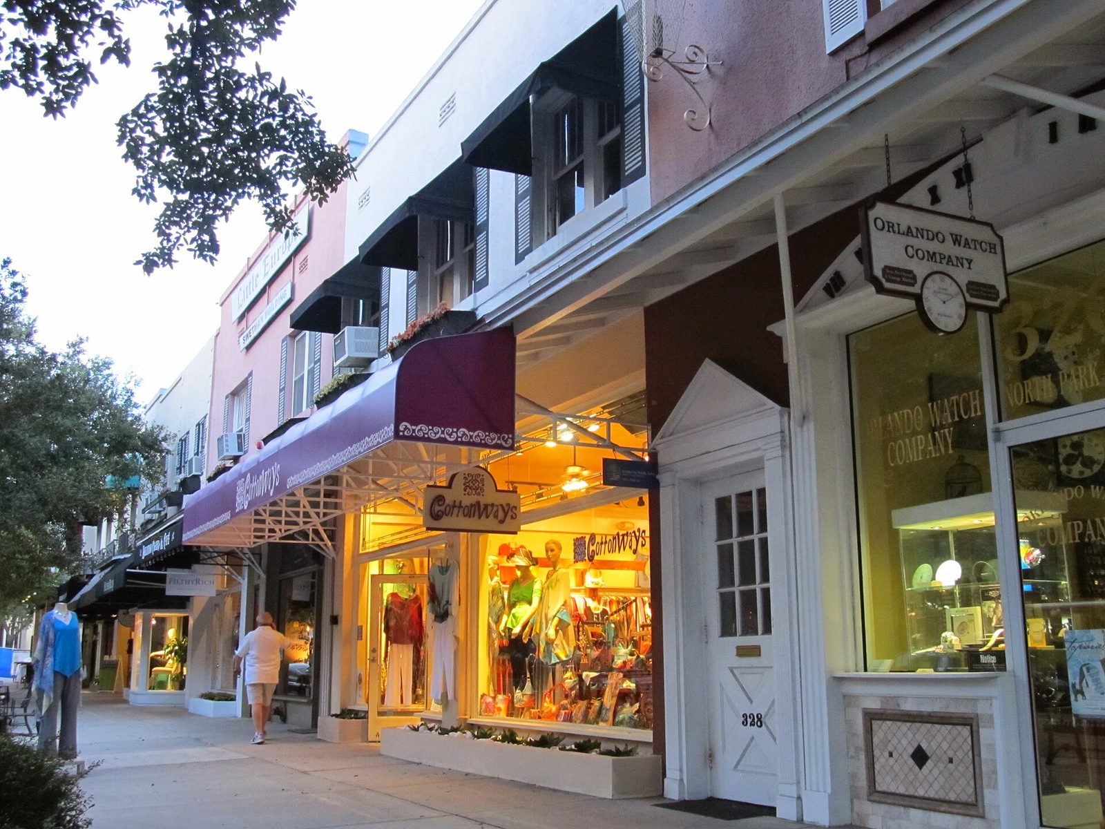Shop windows lit at dusk along Park Avenue in Winter Park, Florida
